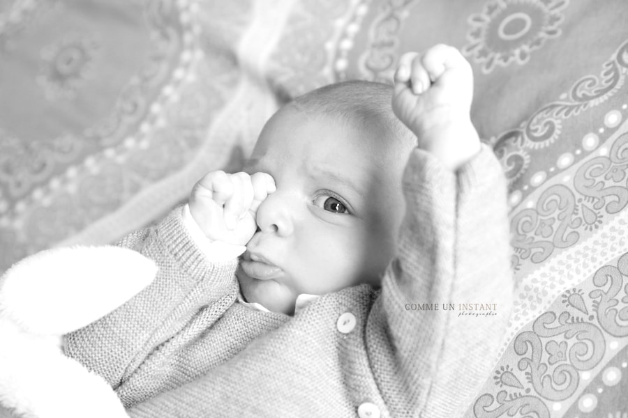 photographe bébé, bébé aux yeux bleus, nouveau né, noir et blanc, nouveau né studio, photographe a domicile bébés en plein coeur de Versailles (78000 Yvelines 78) et sa région, shooting à domicile bébé en train de jouer, petites mains, photographie bébé studio