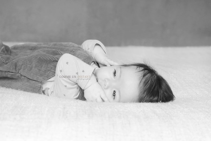 photographe à domicile amour, noir et blanc, photographie bébé studio, photographe à domicile de bébés a Saint Germain en Laye (78100 Yvelines 78) et sa région, photographie enfant studio, bébé en train de jouer, shooting à domicile bébé, photographe professionnelle bébé aux yeux bleus, enfant