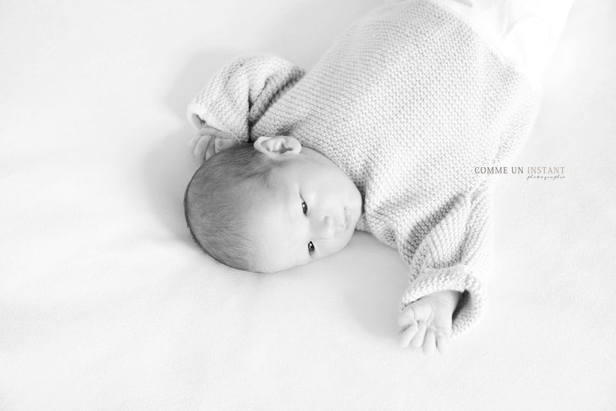 bébé aux yeux bleus - shooting à domicile nouveau né - shooting nouveau né studio - petites mains - noir et blanc - bébé - photographe professionnelle bébé studio - reportage photographe nouveau ne