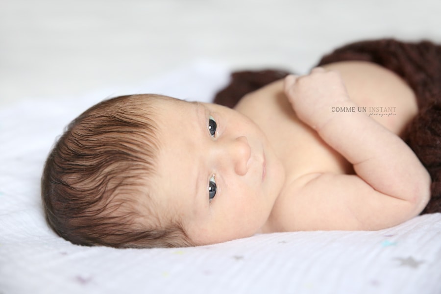 bébé aux yeux bleus - photographe professionnelle de bebe - photographe bébé studio - photographe pro nouveau né - petites mains - photographie bébé - photographie nouveau né studio