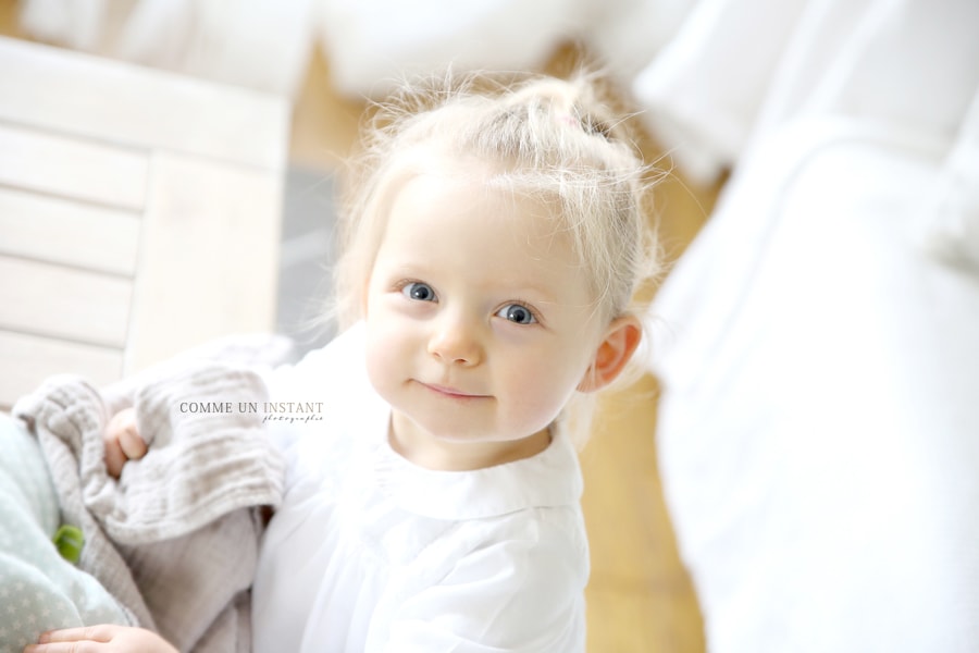 bébé aux yeux bleus, reportage photographe bébé en train de jouer, photographe a domicile enfant en train de jouer, photographe a domicile enfants a Paris 75 tout près des Champs de Mars et de la Concorde