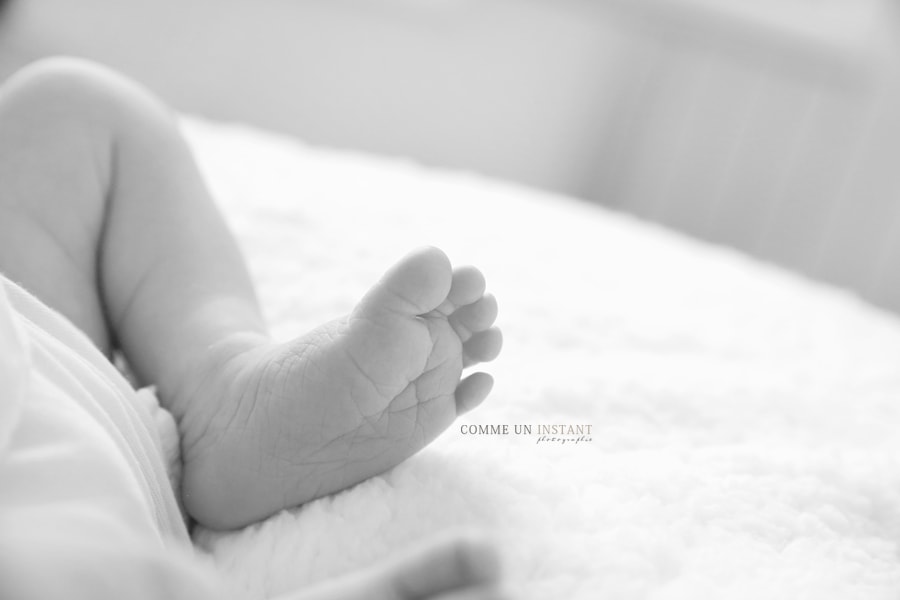 photographe professionnelle nouveau né en train de dormir, photographe pro nouveau né, photographe bébé, nouveau né studio, shooting de bébés, photographie noir et blanc, petits pieds, petit peton