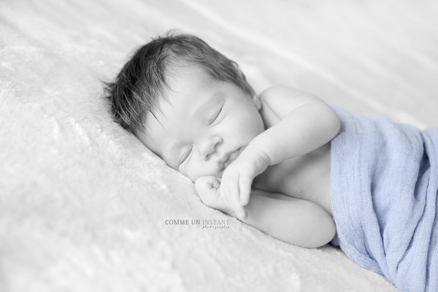 photographie noir et blanc - couleur isolée - bébé en train de dormir - reportage photographe de bebes à Paris 75 et sa région au niveau de la cathédrale Notre Dame - photographe professionnelle nouveau né en train de dormir